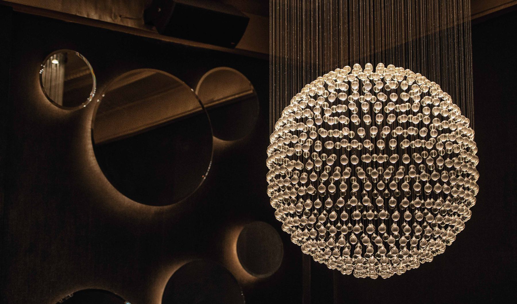 The crystal sphere chandelier and mirrored wall of the Edison Ballroom